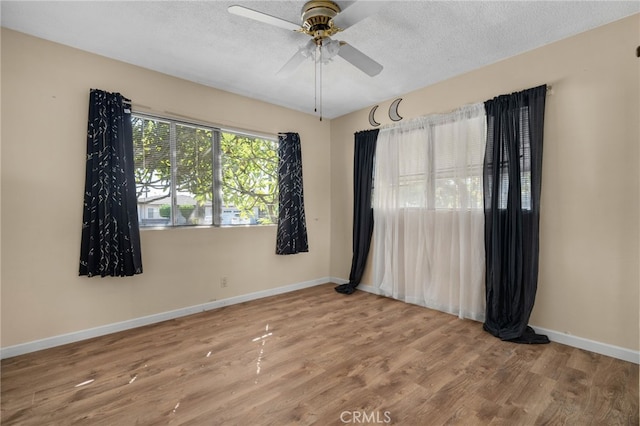 empty room featuring hardwood / wood-style floors, ceiling fan, and a textured ceiling