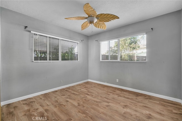 empty room featuring a textured ceiling, light hardwood / wood-style floors, and ceiling fan