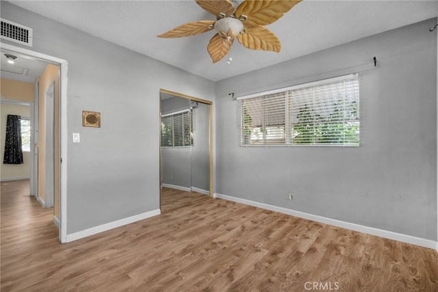 spare room with ceiling fan, light hardwood / wood-style floors, and a textured ceiling