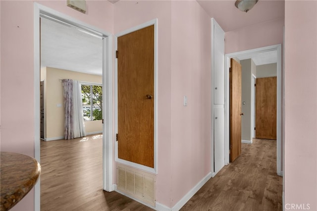 hallway with hardwood / wood-style floors