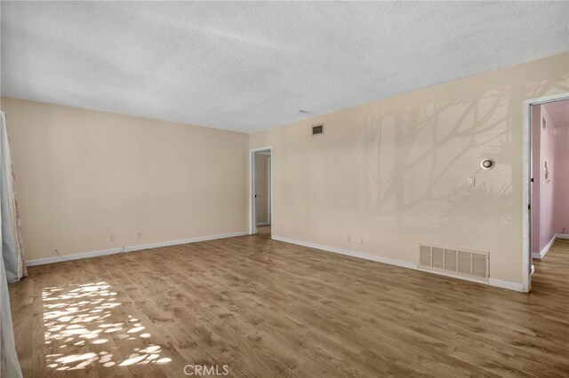 8653 Norwood Pl, Rosemead, CA 91770 - empty room with a textured ceiling, wood finished floors, and baseboards