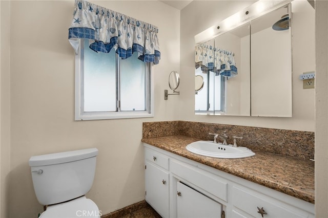 bathroom with vanity, toilet, and plenty of natural light