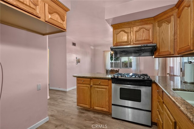 8653 Norwood Pl, Rosemead, CA 91770 - kitchen featuring stainless steel range with gas stovetop, range hood, dark stone countertops, baseboards, and light wood-style floors