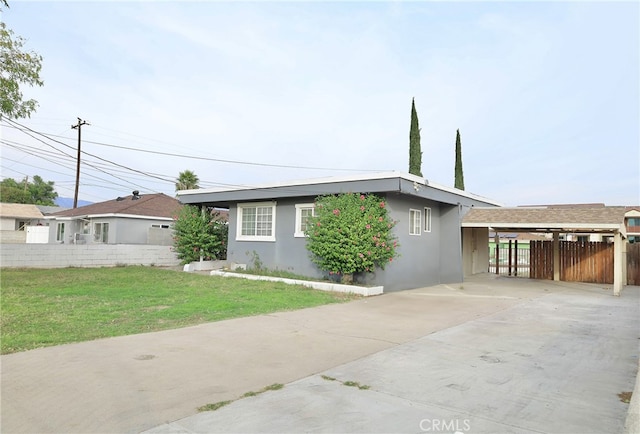 ranch-style house with a carport and a front lawn