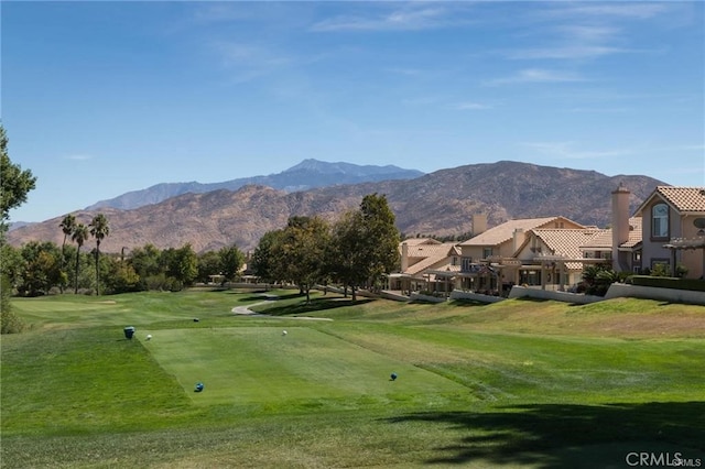 surrounding community with a mountain view and a yard