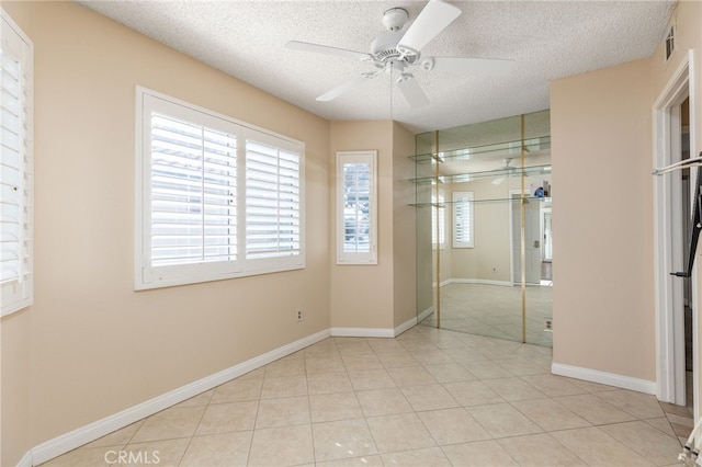 interior space featuring ceiling fan, light tile patterned floors, a closet, and a textured ceiling