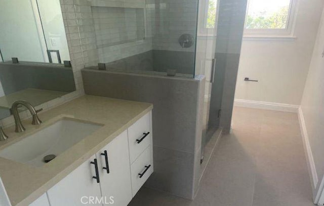 bathroom featuring vanity and a shower with shower door