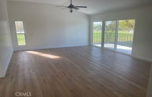 empty room with vaulted ceiling, ceiling fan, and dark wood-type flooring