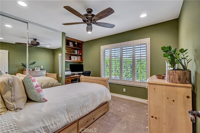 carpeted bedroom featuring ceiling fan and a closet