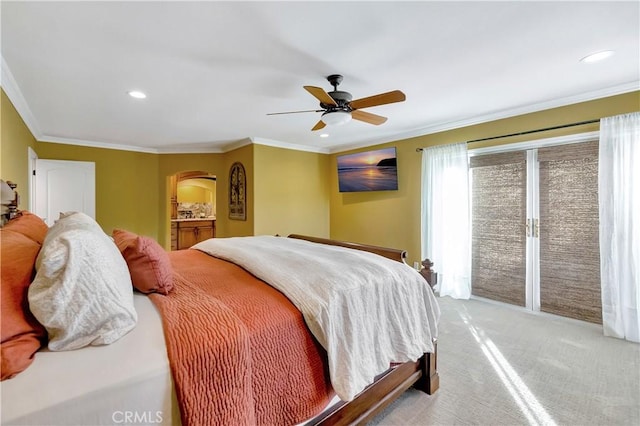 carpeted bedroom featuring access to exterior, ensuite bathroom, ceiling fan, and ornamental molding