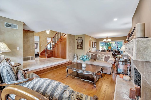 living room with an inviting chandelier and light hardwood / wood-style flooring