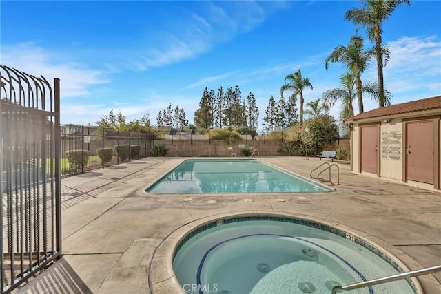 view of swimming pool featuring a patio area and an in ground hot tub