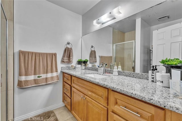 bathroom featuring tile patterned flooring, vanity, and a shower with door