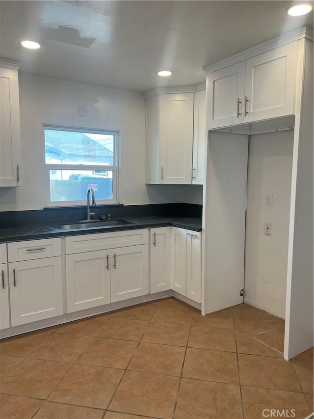 kitchen with white cabinets, light tile patterned floors, and sink