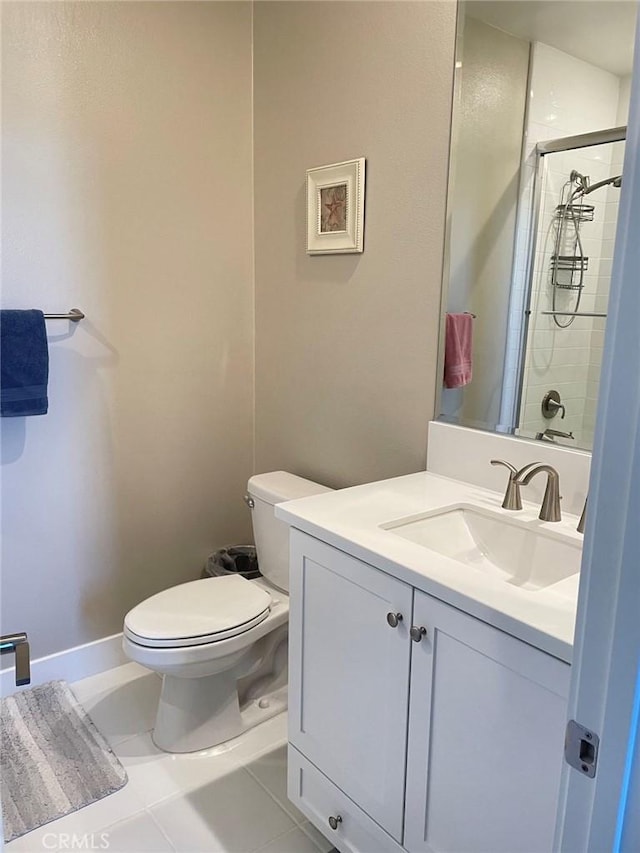 bathroom with tile patterned flooring, vanity, toilet, and a shower with door