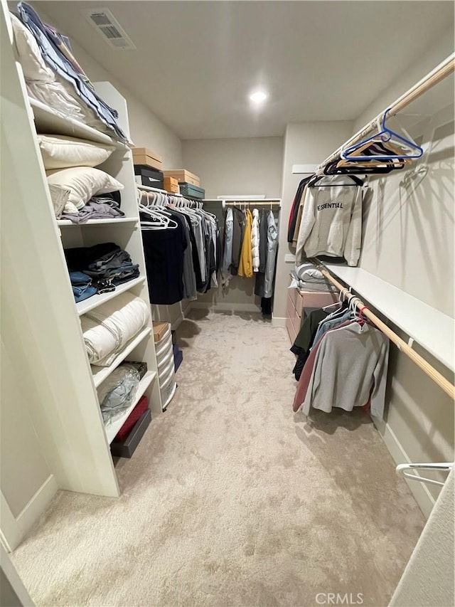 walk in closet featuring light colored carpet