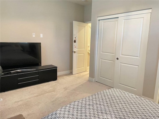 bedroom featuring light carpet and a closet