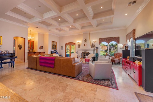 living room featuring crown molding, a fireplace, a towering ceiling, and a notable chandelier