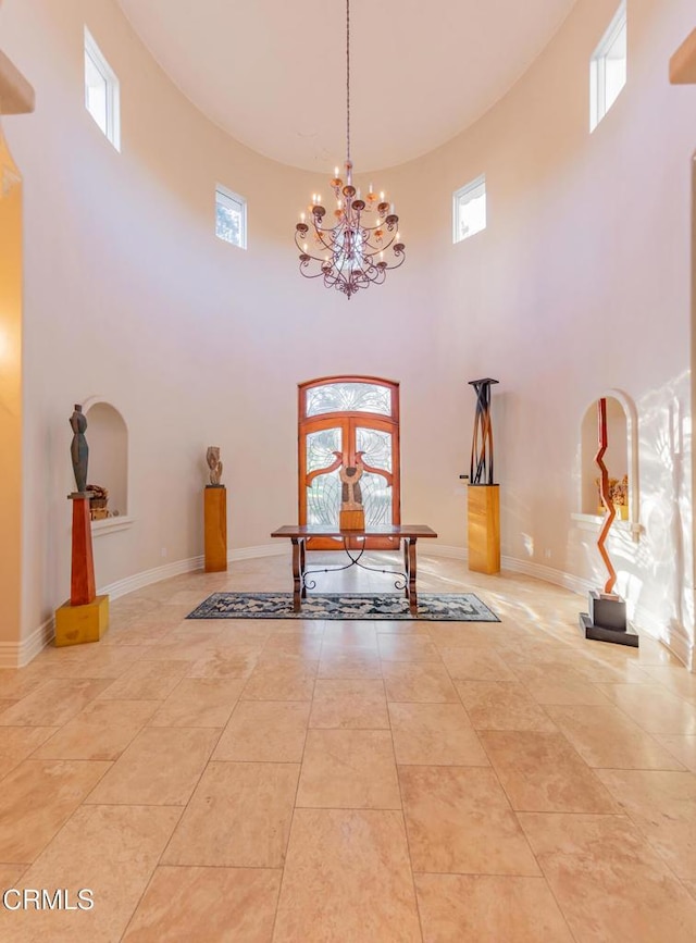 entrance foyer with light tile patterned floors, french doors, an inviting chandelier, and baseboards