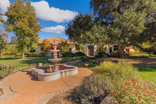 view of front of home with a tiled roof and a front yard