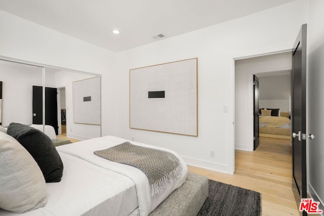 bedroom featuring light wood-type flooring and a closet