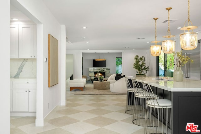 kitchen featuring white cabinets, plenty of natural light, and decorative light fixtures