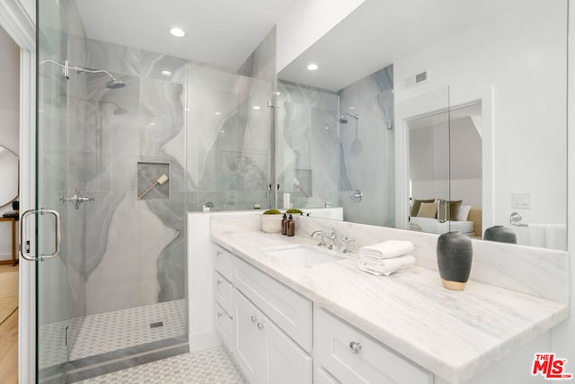 bathroom featuring vanity and a shower with shower door