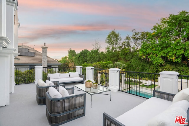 patio terrace at dusk with an outdoor hangout area and a swimming pool