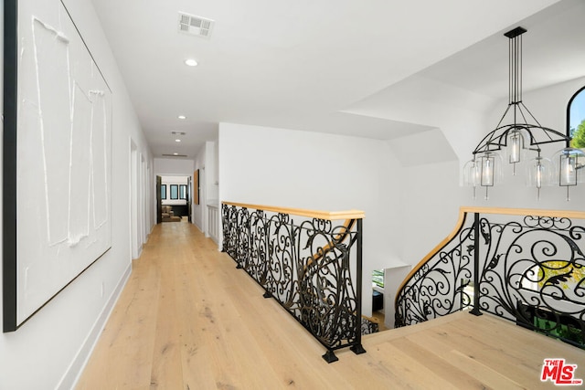 corridor featuring a chandelier and wood-type flooring