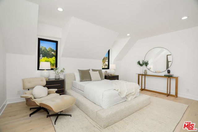 bedroom featuring light hardwood / wood-style floors and lofted ceiling