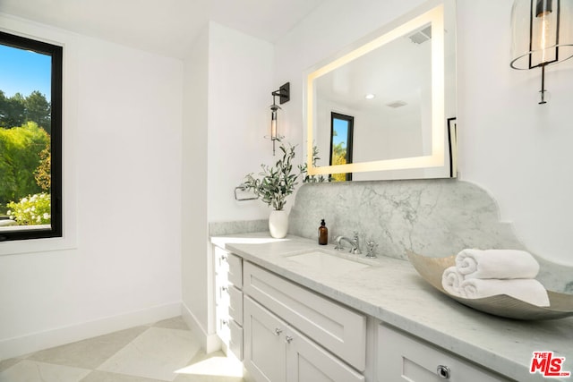 bathroom with tile patterned floors, plenty of natural light, decorative backsplash, and vanity