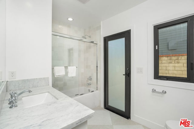 full bathroom with tile patterned floors, vanity, toilet, and bath / shower combo with glass door