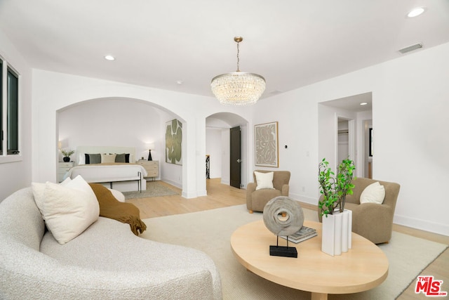 living room featuring an inviting chandelier and light wood-type flooring