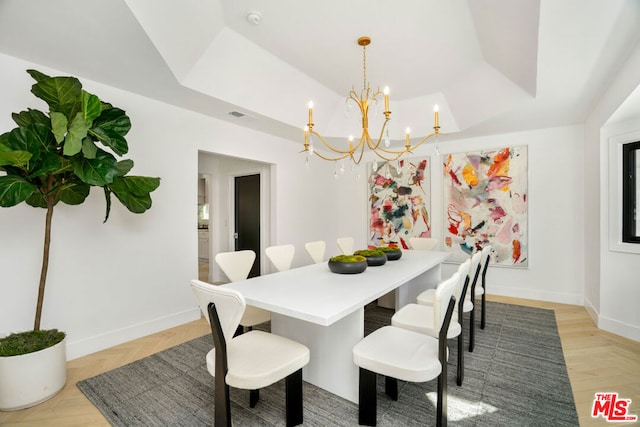 dining area featuring a tray ceiling and a notable chandelier