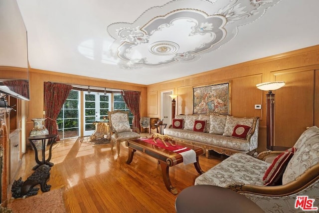 living room featuring light hardwood / wood-style flooring and wooden walls