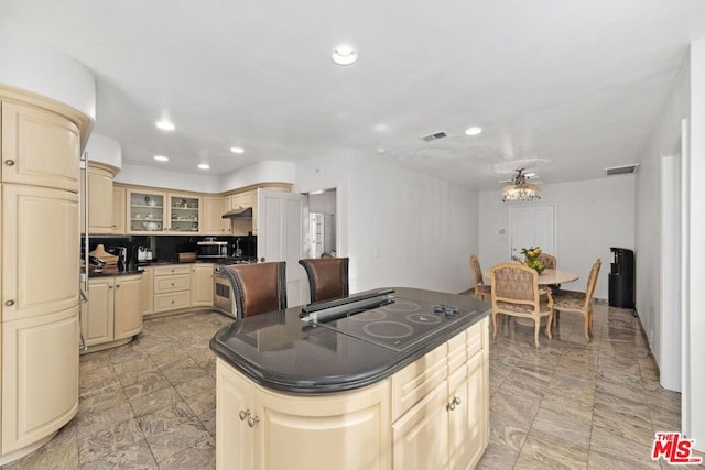 kitchen featuring tasteful backsplash, stainless steel appliances, and cream cabinetry