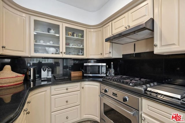 kitchen with cream cabinetry, stainless steel appliances, and tasteful backsplash