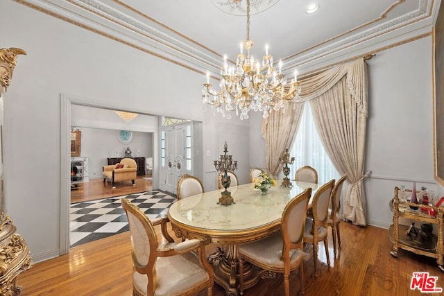 dining room featuring hardwood / wood-style flooring, ornamental molding, and an inviting chandelier