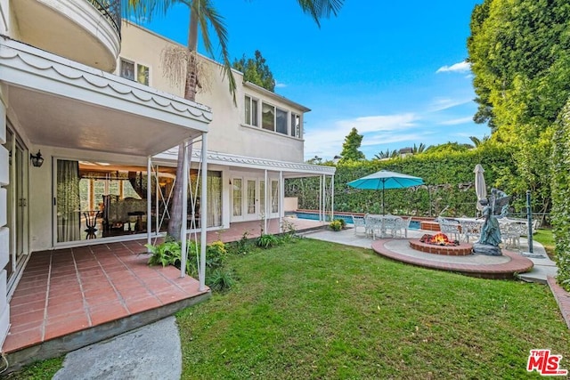 view of yard with french doors, an outdoor fire pit, and a patio area