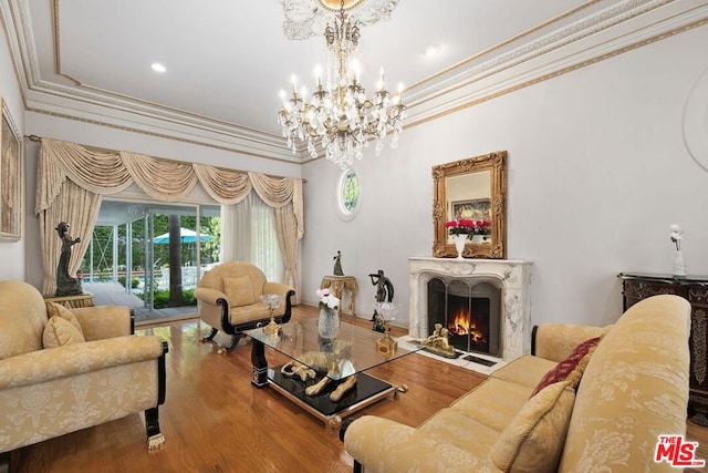 living room with ornamental molding, a high end fireplace, a chandelier, and hardwood / wood-style flooring