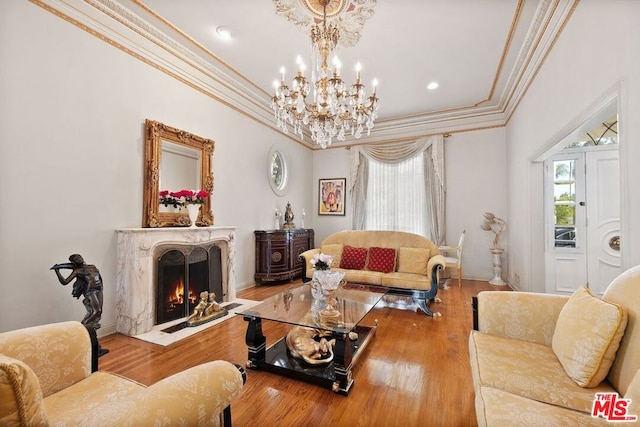 living room featuring hardwood / wood-style flooring, a high end fireplace, crown molding, and a wealth of natural light