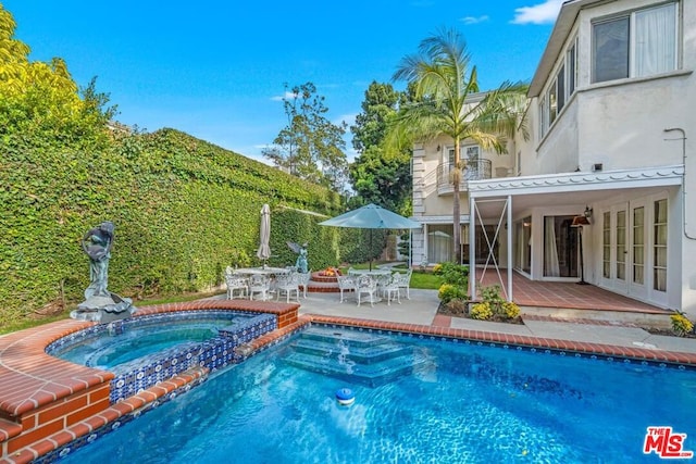 view of swimming pool with an in ground hot tub, french doors, and a patio