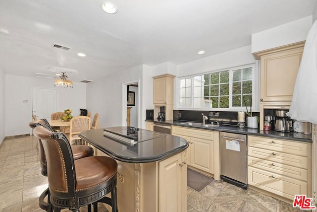 kitchen featuring sink, a kitchen island, cream cabinetry, and appliances with stainless steel finishes