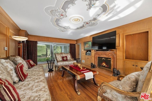 living room with hardwood / wood-style flooring and wooden walls