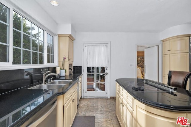 kitchen with black electric stovetop, stainless steel dishwasher, sink, cream cabinets, and dark stone countertops