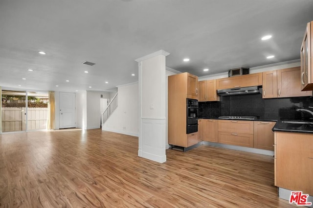 kitchen featuring backsplash, light hardwood / wood-style flooring, crown molding, and sink