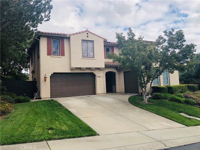 mediterranean / spanish-style house with a garage and a front lawn