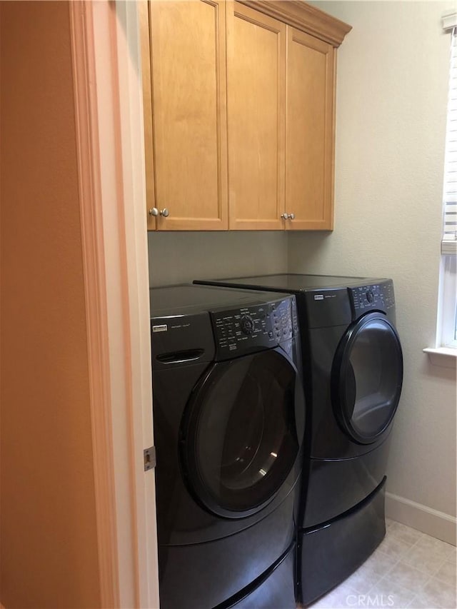 washroom featuring cabinets and washer and dryer