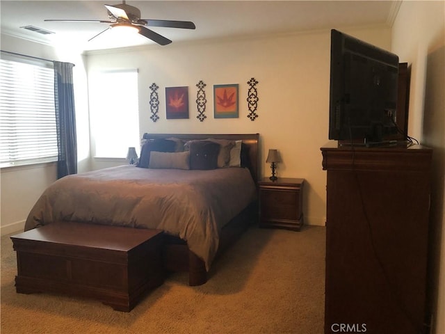 carpeted bedroom with ceiling fan and ornamental molding