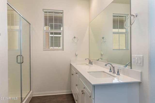 bathroom with wood-type flooring, vanity, and an enclosed shower